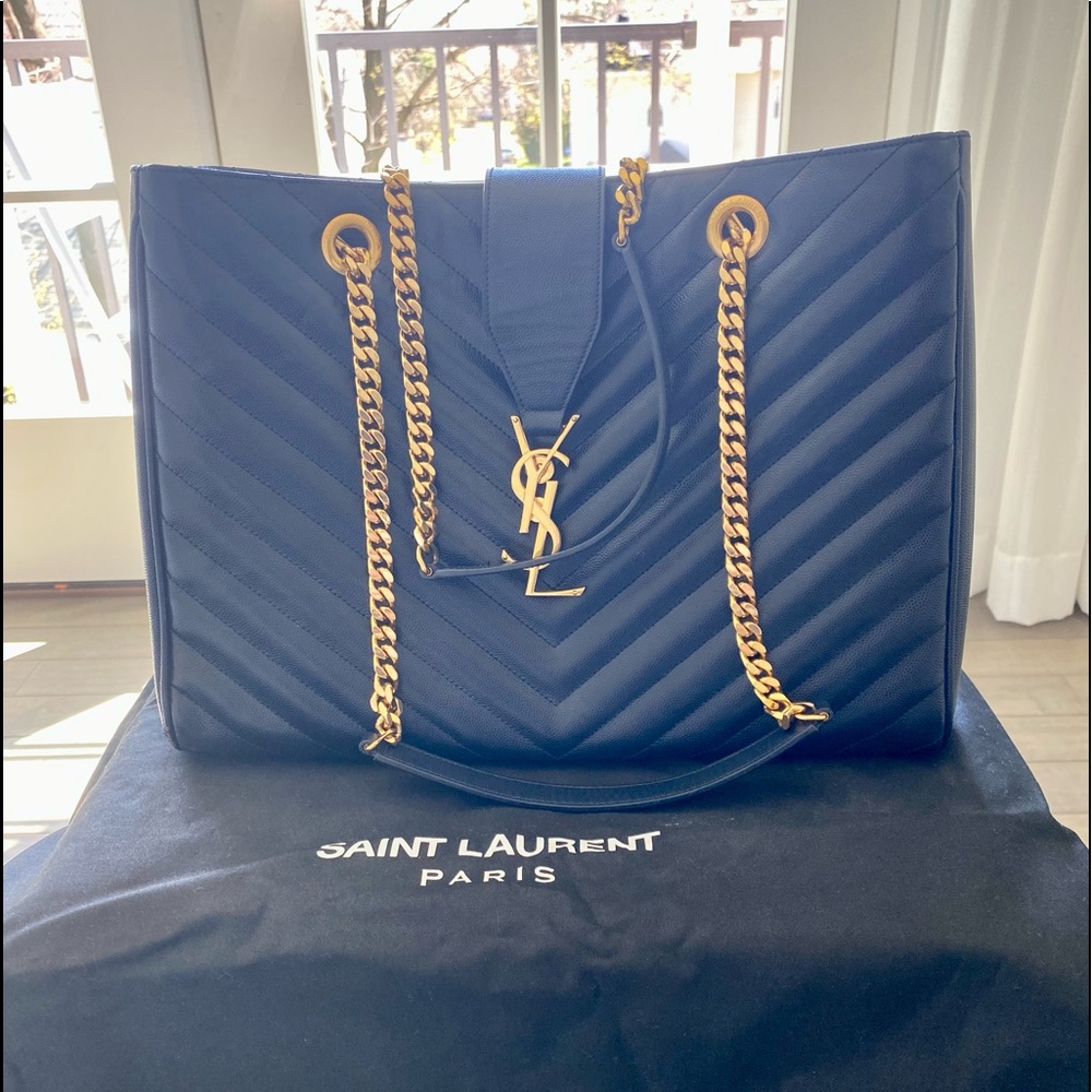 This is the YSL navy medium shoulder bag with gold chains and gold logo closure.